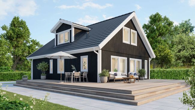Ett svart 1,5-planshus omgiven av terass och grönska
