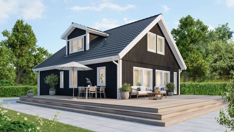 Ett svart 1,5-planshus omgiven av terass och grönska