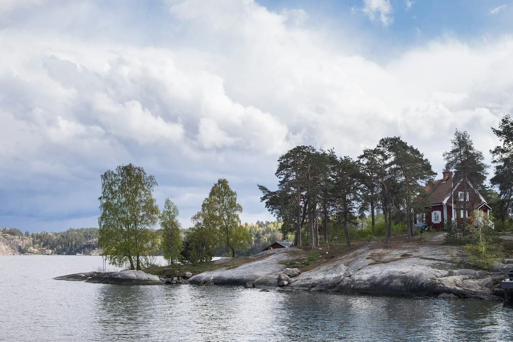 Ett rött trähus på en klippa i skärgården