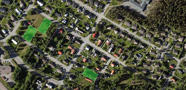 Övergripande flygbild över ett bostadsområde och utritade tomtgränser